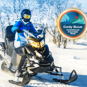 Person riding snowmobile in snowy landscape.